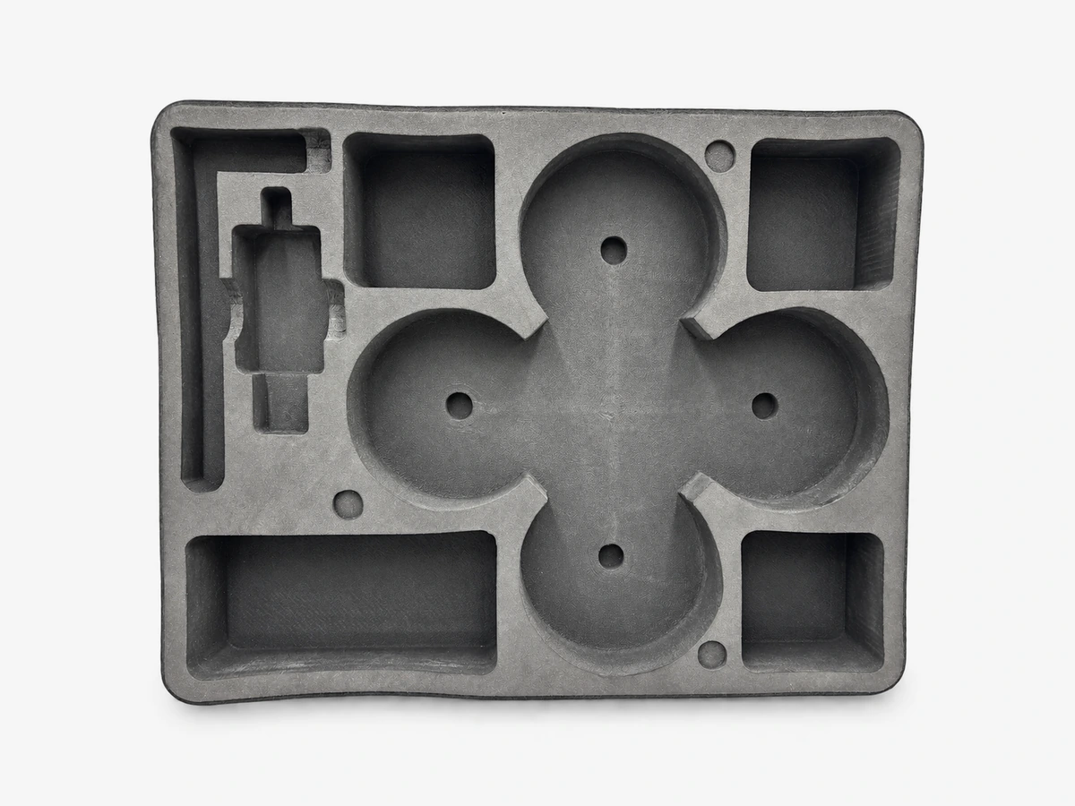 Illustration d’application adaptée : vue de dessus légèrement inclinée d’un insert EVA pour drone et accessoires, avec logements circulaires, poches rectangulaires, petits trous et logement latéral profilé.
